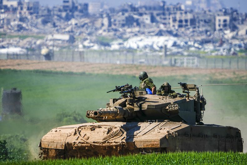 Soldados israelíes conducen un tanque en la frontera con la Franja de Gaza el domingo 11 de febrero de 2024, vistos desde el sur de Israel. (AP Foto/Ariel Schalit)