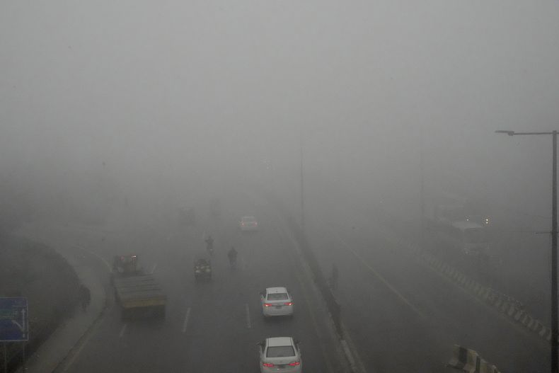 Varios vehículos avanzan lentamente debido a la reducción de la visibilidad provocada por el smog que envuelve el área de Lahore, Pakistán, el martes 12 de noviembre de 2024. (AP Foto/K.M. Chaudary)