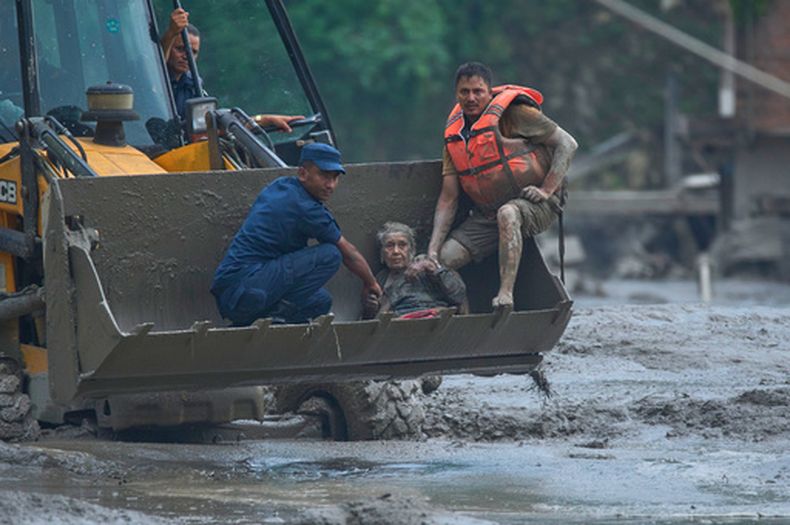 Rescatistas usan una excavadora para poner a salvo a las víctimas de una inundación a lo largo del río Trishuli, el miércoles 28 de agosto de 2026, en el distrito de Nuwakot, Nepal. (AP Foto/Niranjan Shrestha)