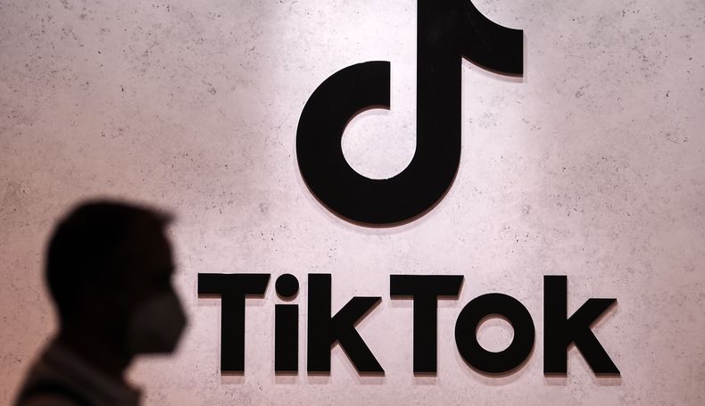 ARCHIVO – Un visitante pasa frente a los espacios de exhibición de TikTok en la feria de juegos de computadora de Colonia, Alemania, el jueves 25 de agosto de 2022. (AP Foto/Martin Meissner, Archivo)