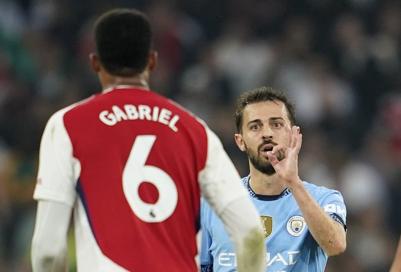 Bernardo Silva del Manchester City gesticula ante Gabriel de Arsenal en el partido de la Liga Premier, el domingo 22 de septiembre de 2024. (AP Foto/Dave Thompson)