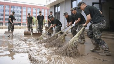 En esta foto distribuida por la agencia de noticias estatal china, Xinhua, efectivos de la policía armada limpian una inundación causada por los aguaceros del tifón Doksuri en una escuela secundaria en Zhuozhou, en la provincia de Hebei, en el norte de China, el 10 de agosto de 2023. (Zhu Xudong/Xinhua vía AP)