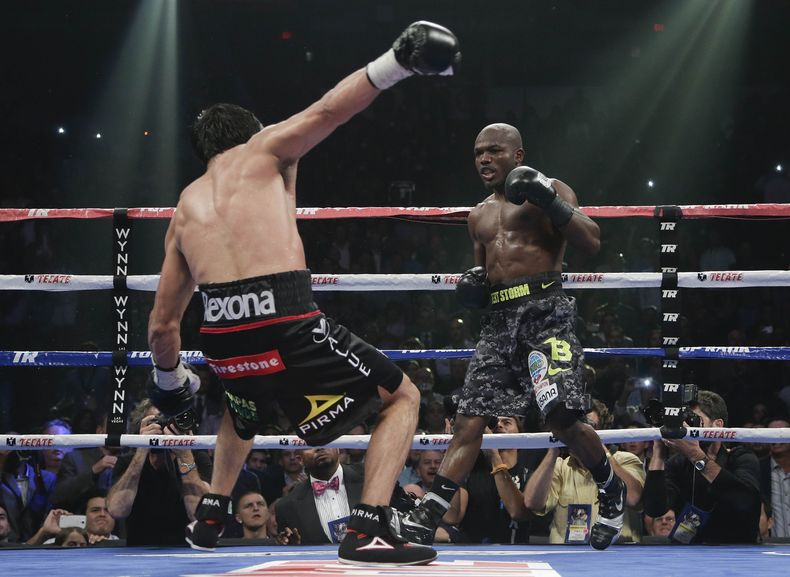 El mexicano Juan Manuel M&aacute;rquez se tambalea hacia atr&aacute;s luego de recibir un pu&ntilde;etazo de Timothy Bradley en el duod&eacute;cimo asalto de la pelea realizada el s&aacute;bado 12 de octubre de 2013, por el t&iacute;tulo w&eacute;lter de
