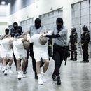 En esta fotografía proporcionada por la oficina de prensa de la presidencia de El Salvador, guardias penitenciarios trasladan a presuntos pandilleros venezolanos, deportados de Estados Unidos, al Centro de Confinamiento del Terrorismo (CECOT), en Tecoluca, El Salvador, el domingo 16 de marzo de 2025. (Oficina de prensa de la presidencia de El Salvador vía AP)