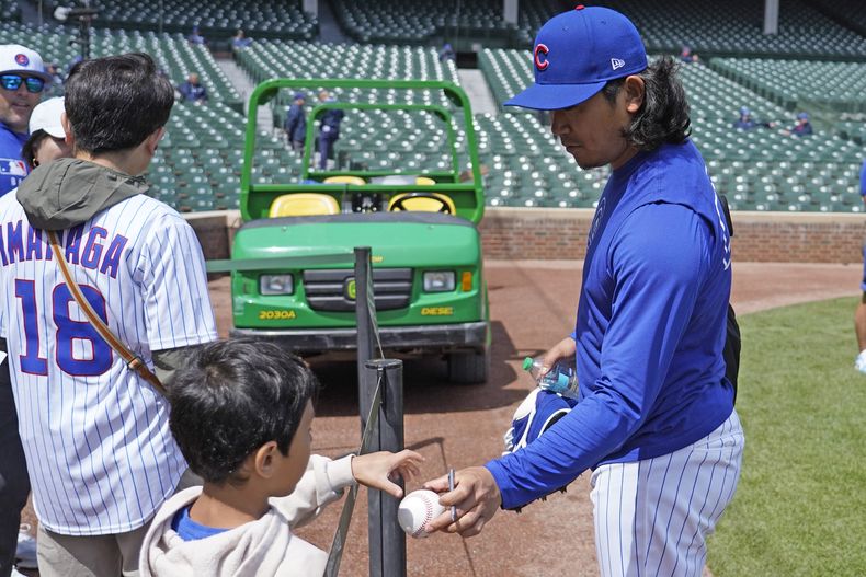 El lanzador Shota Imanaga de los Cachorros de Chicago firma autógrafos antes de un partido de béisbol contra los Rockies de Colorado el lunes 26 de mayo de 2025, en Chicago. (AP Foto/David Banks)
