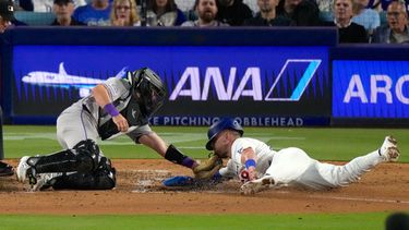 Dalton Rushing (derecha), de los Dodgers de Los Ángeles, es puesto fuera (tagged out) por el receptor de los Rockies de Colorado, Braxton Fulford, mientras intenta anotar tras un toque de bola de jugada de selección de Miguel Rojas durante la quinta entrada de un partido de béisbol, el martes 7 de julio de 2026, en Los Ángeles. (Foto AP/Mark J. Terrill)