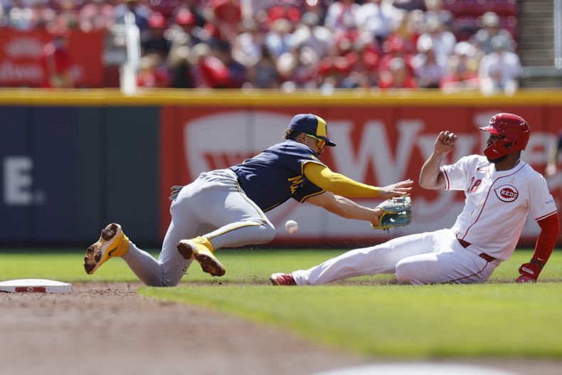 Amed Rosario de los Rojos de Cincinnati se desliza hacia segunda frente al campocorto de los Cerveceros de Milwaukee Willy Adames el domingo primero de septiembre del 2024. (AP Foto/Jay LaPrete)