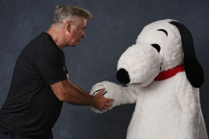 Alec Baldwin, a la izquierda, y una persona vestida como el personaje Snoopy de Peanuts posan para un retrato para promocionar el 75º aniversario de Peanuts durante la Comic-Con International el jueves 24 de julio de 2025 en San Diego. (Foto AP/Chris Pizzello)