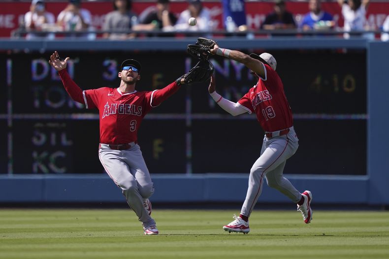 Kyren Paris, de los Angelinos de Los Ángeles, a la derecha, atrapa una pelota bateada por Mookie Betts, de los Dodgers de Los Ángeles, mientras Taylor Ward choca con él durante la séptima entrada el domingo 18 de mayo de 2025, en Los Ángeles. (AP Foto/Mark J. Terrill)