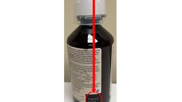 La foto distribuida por la Administración de Alimentos y Medicamentos (FDA) muestra la ubicación del número de lote del jarabe para la tos Robitussin retirado de la venta el jueves 25 de enero de 2024. El retiro se debe a una posible contaminación que podría causar trastornos graves a personas con el sistema inmunitario debilitado. (U.S. Food & Drug Administration via AP)
