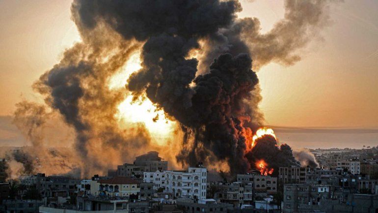 Los bomberos israelíes, las fuerzas de seguridad y de rescate se encuentran junto a un autobús y un automóvil en llamas que fueron alcanzados por un cohete disparado desde Gaza hacia Holon. REUTERS/Gidon Markovitz.