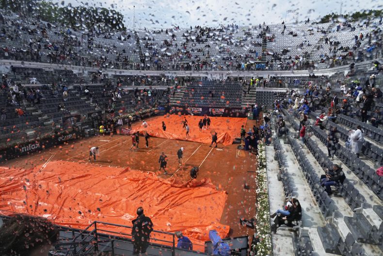 La lona es removida del Campo Centrale previo a la final del Abierto de Italia entre Holger Rune y Daniil Medvedev, el domingo 21 de mayo de 2023. (AP Foto/Gregorio Borgia)