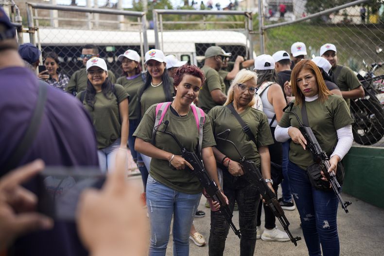 Miembros de milicias respaldadas por el gobierno posan con rifles antes de una marcha en Caracas, Venezuela, el martes 7 de enero de 2025, días antes de la toma de posesión del presidente Nicolás Maduro para un tercer mandato. (AP Foto/Matías Delacroix)
