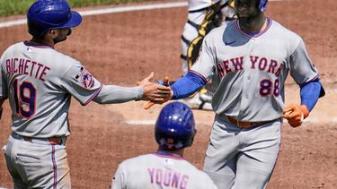Luis Robert Jr. (88), de los Mets de Nueva York, es recibido en el plato por Bo Bichette (19) mientras se enfila al dugout después de batear un jonrón de dos carreras frente al lanzador de los Piratas de Pittsburgh, Jared Jones, durante la tercera entrada del juego de béisbol de Grandes Ligas, el domingo 9 de agosto de 2026, en Pittsburgh. (AP Foto/Gene J. Puskar)