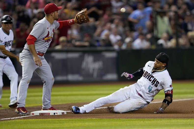 El dominicano Ketel Marte, de los Diamondbacks de Arizona, se desliza en la antesala con un triple ante Nolan Arenado, de los Cardenales de San Luis, el martes 25 de julio de 2023 (AP Foto/Matt York)