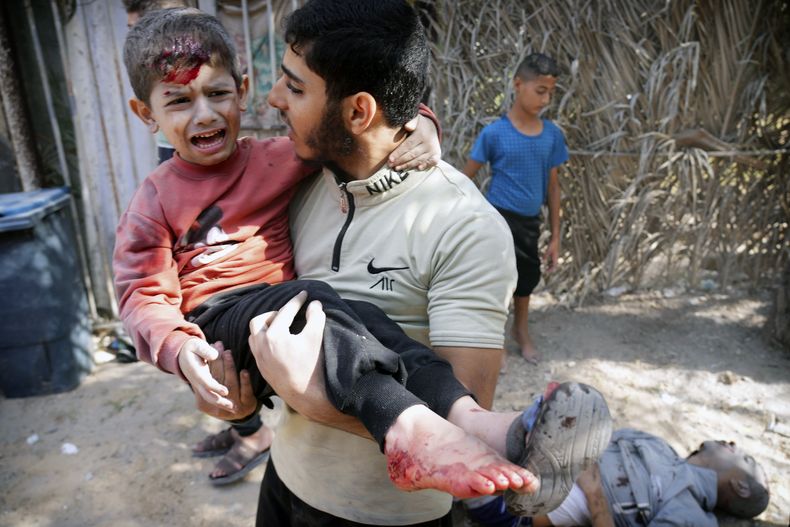 Un niño herido es cargado por un joven luego de un ataque aéreo israelí en Deir Al-Balah, el jueves 9 de noviembre de 2023, en el sur de la Franja de Gaza. (AP Foto/Hatem Moussa)