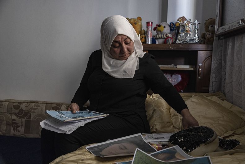 Hamrin Alouji, madre de Peyal Aqil, de 13 años, revisa las fotos de su hija en su casa en Qamishli, Siria, el 5 de junio de 2023.(AP Foto/Baderkhan Ahmad)