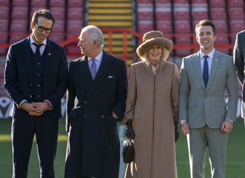 ARCHIVO - El rey Carlos III de Gran Bretaña, segundo a la izquierda y Camilla, la reina consorte, segunda a la derecha, hablan con los copropietarios del club de fútbol Wrexham, los actores Ryan Reynolds (izquierda) y Rob McElhenney durante su visita al hipódromo del Wrexham Football Club, en Wrexham, Gales, el viernes 1 de diciembre de 2022. (Arthur Edwards/Pool Photo vía AP)