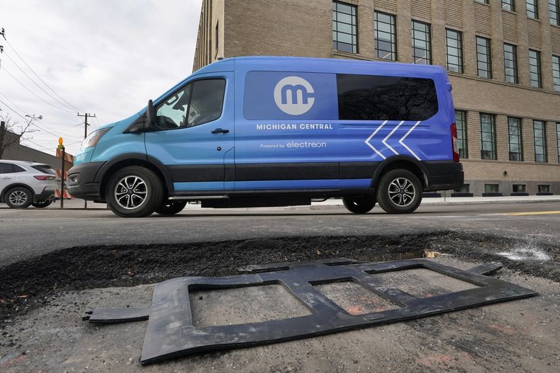 Una camioneta eléctrica pasa el miércoles 29 de noviembre de 2023 frente a una bobina de cobre de carga inalámbrica que será instalada en una calle de Detroit para que los vehículos eléctricos puedan cargar sus baterías al pasar por ahí, quedarse parados o estacionados. (AP Foto/Paul Sancya)