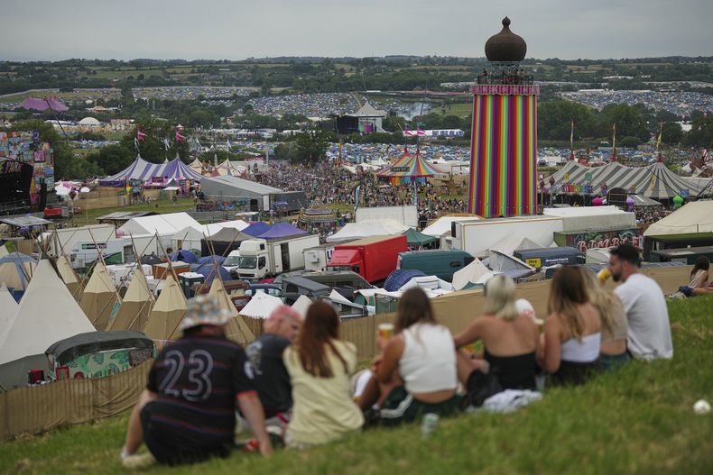 Asistentes sentados fuera de un bar durante el Festival de Glastonbury en Worthy Farm, Somerset, Inglaterra, el miércoles 25 de junio de 2025. (Scott A Garfitt/Invision/AP)
