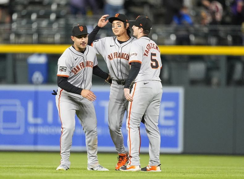 El jardinero izquierdo de los Gigantes de San Francisco, Michael Conforto, el jardinero central Jung Hoo Lee y el jardinero derecho, Mike Yastrzemski, de izquierda a derecha, celebran después de la victoria del equipo en un juego de béisbol contra los Rockies de Colorado el miércoles 8 de mayo de 2024, en Denver. (AP Foto/David Zalubowski)