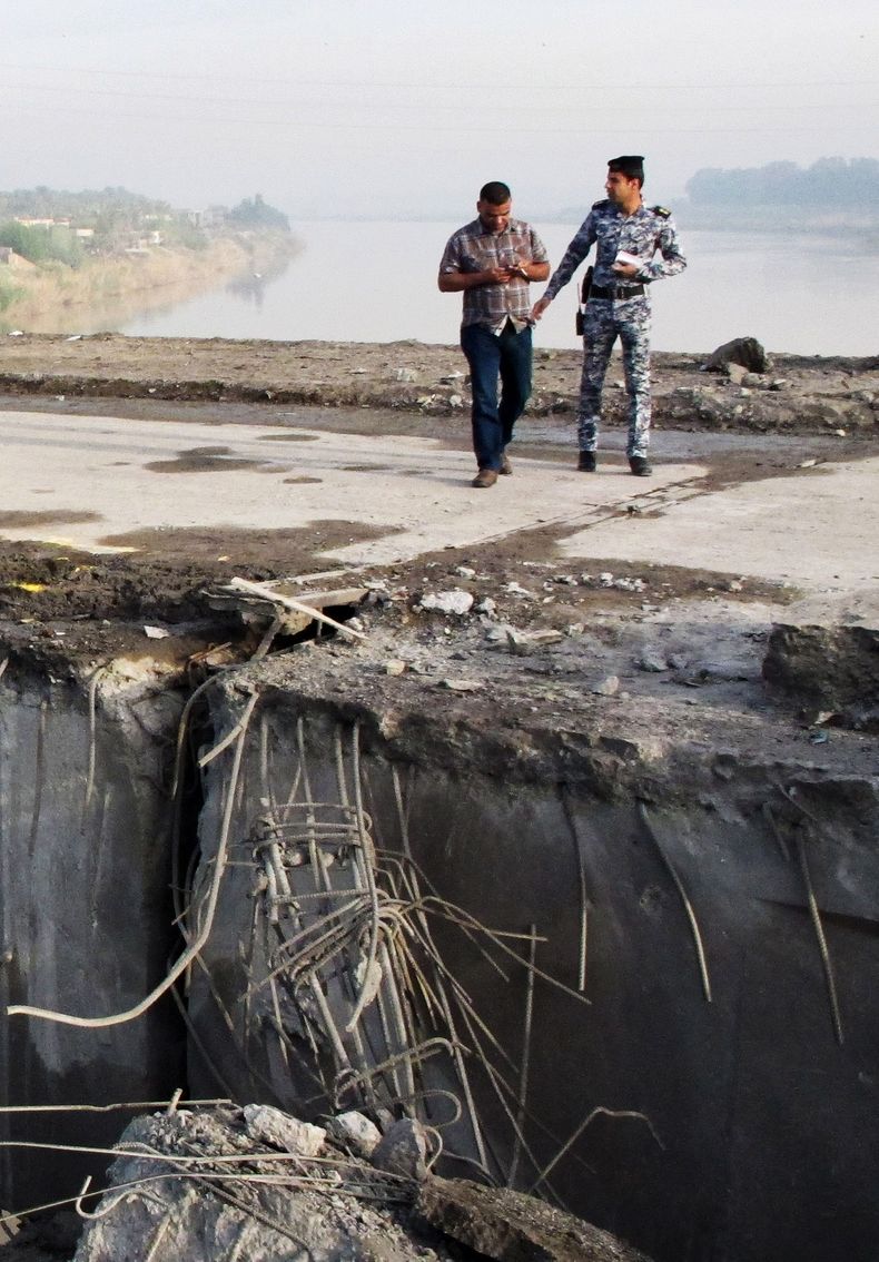 Agentes de seguridad inspeccionan los da&ntilde;os causados al puente Muthana, sobre el r&iacute;o Tigris, en el norte de Bagdad, Irak, el mi&eacute;rcoles 26 de marzo de 2014. Un atacante suicida estrell&oacute; el martes su veh&iacute;culo cargado con e