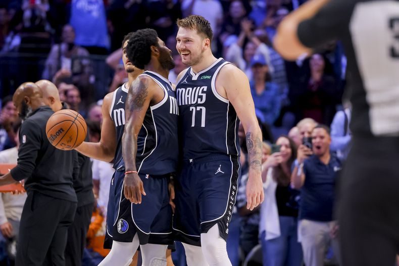 Luka Doncic (77) y Kyrie Irving (11) de los Mavericks de Dallas celebran durante la 2da mitad del juego de la NBA ante los Nets de Brooklyn, en Dallas, el viernes 27 de octubre de 2023. (AP Foto/Gareth Patterson)