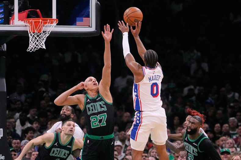 El base de los 76ers de Filadelfia, Tyrese Maxey (0), realiza un tiro por encima del base de los Celtics de Boston, Jordan Walsh (27), durante la primera mitad del quinto juego de una serie de la primera ronda de los playoffs de la NBA, el martes 28 de abril de 2026, en Boston. (AP Foto/Charles Krupa)