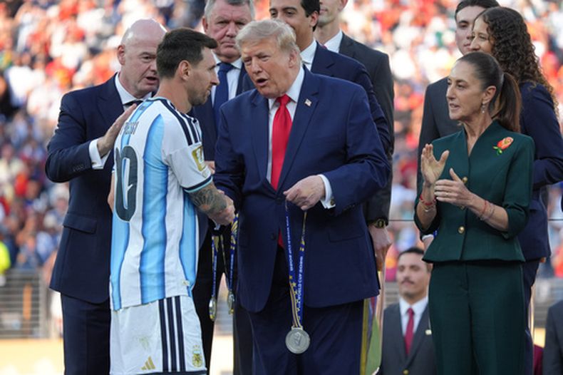 Flanqueado por el líder de la FIFA Gianni Infantino y la presidenta de México Claudia Sheinbaum, el presidente estadounidense Donald Trump entrega a Lionel Messi su medalla de subcampeón tras la final de la Copa del Mundo ante España, el domingo 19 de julio de 2026 (AP Foto/Jacquelyn Martin)