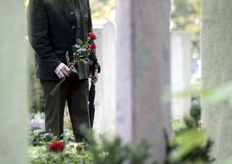 Una persona frente a una tumba en el cementerio de Waldfriedhof en Munich, Alemania, el 1 de noviembre del 2006. (AP foto/Christof Stache)