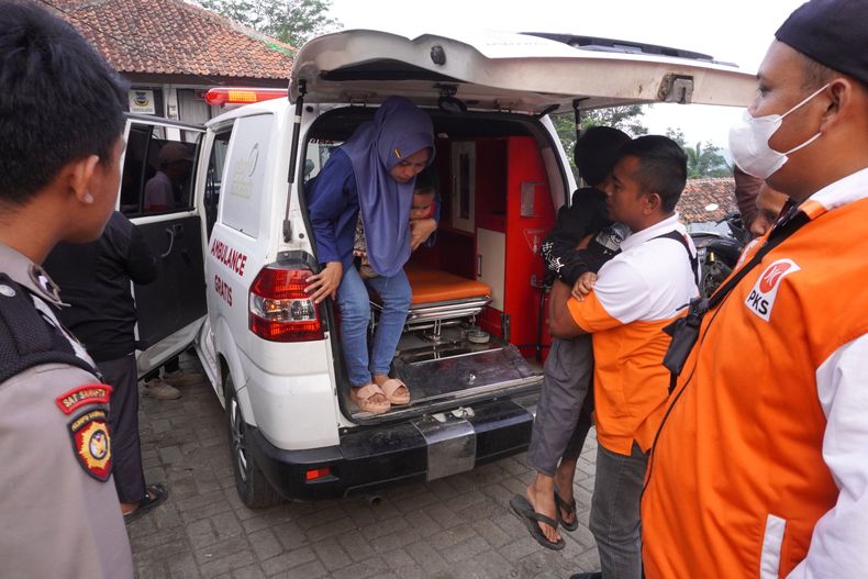 Personal sanitario recibe a niños que enfermaron por intoxicación alimentaria a su llegada en ambulancia al Hospital Cililin en Bandung Occidental, Indonesia, el jueves 25 de septiembre de 2025. (AP Foto/Adnan Kheruma)