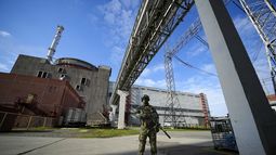 ARCHIVO - Un militar ruso vigila una zona en torno a la central nuclear de Zaporiyia, en territorio bajo control ruso, en el sureste de Ucrania, el 1 de mayo de 2022. El jefe de la agencia de supervisión nuclear de Naciones Unidas, Rafael Grossi, expresó su creciente ansiedad sobre la seguridad de la planta después de que el gobernador regional ordenara la evacuación de una localidad donde vive la mayoría de los trabajadores de la central, en medio de ataques a la zona. (AP Foto/Archivo)