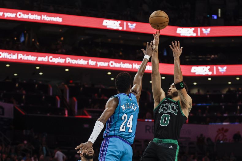 Jayson Tatum (0), de los Celtics de Boston, tira sobre Brandon Miller (24), de los Hornets de Charlotte, durante la segunda mitad del juego de baloncesto de la NBA, en Charlotte, Carolina del Norte, el lunes 1 de abril de 2024. (AP Foto/Nell Redmond)