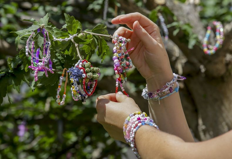 Swifties colocan brazaletes de la amistad en un árbol en el centro de Viena el jueves 8 de agosto de 2024. Los organizadores de tres conciertos de Taylor Swift en un estadio de Viena esta semana los cancelaron el miércoles después de dos arrestos por un aparente complot para lanzar un ataque a un evento masivo en el área de Viena como los conciertos. (Foto AP/Heinz-Peter Bader)