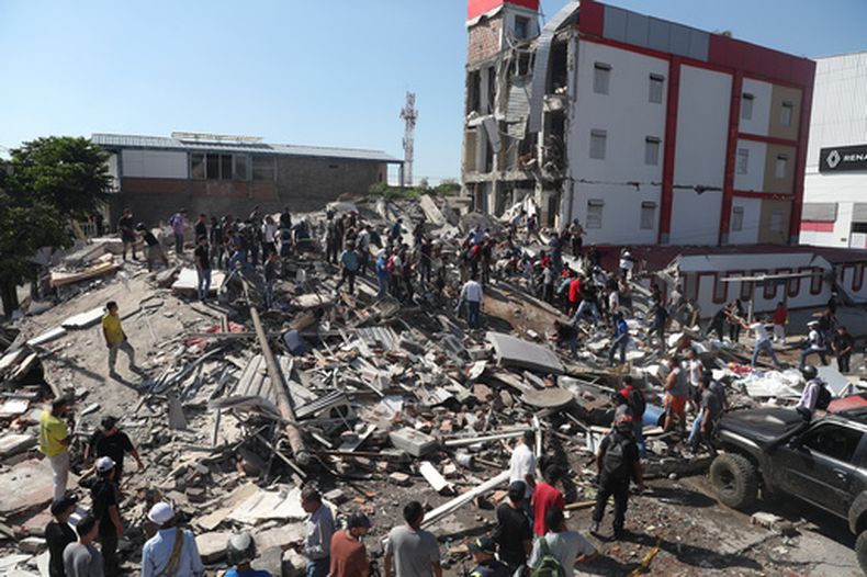 Residentes y equipos de rescate buscan entre los escombros de un edificio derrumbado tras el terremoto que azotó Cali, Colombia, el lunes 10 de agosto de 2026. (AP Foto/Santiago Saldarriaga)