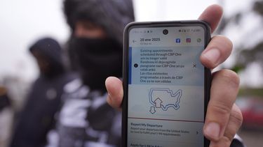 Una persona en Matamoros, México, que solicita asilo en Estados Unidos sostiene un teléfono el lunes 20 de enero de 2025, el cual tiene la app CBP One en la pantalla y muestra que su cita fue cancelada después que Donald Trump asumiera la presidencia de Estados Unidos. (AP Foto/Eric Gay)
