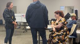 En esta imagen de video entregado por Sheilia Milledge, Paigelynne Gonyea (der) recibe un formulario en un centro de votación en Syracuse, Nueva York, el 23 de junio del 2026. (Sheilia Milledge via AP)