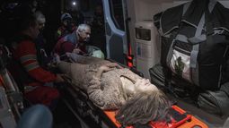 Médicos atienden a una mujer herida en una ambulancia, cerca de una vivienda destruida por un ataque aéreo ruso sobre un vecindario residencial en Kiev, Ucrania, el 24 de abril de 2025. (AP Foto/Evgeniy Maloletka)