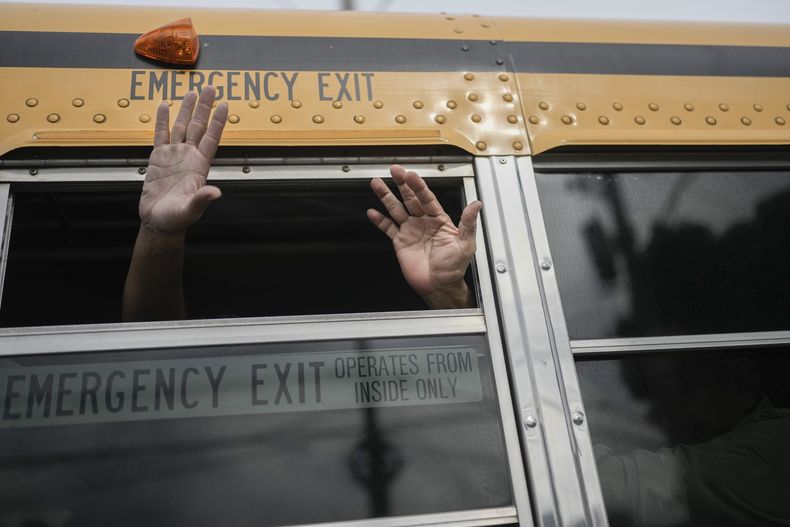 Ciudadanos nicaragüenses saludan desde un bus tras ser liberados de un penal del país y aterrizar en el aeropuerto de la Ciudad de Guatemala, el 5 de septiembre de 2024. (AP Foto/Moisés Castillo)