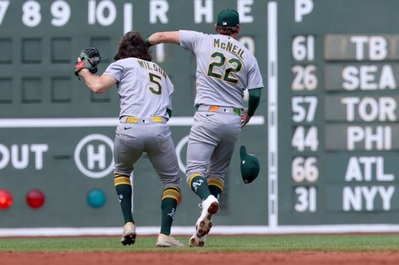 Jacob Wilson (5), de los Atléticos, atrapa un elevado mientras choca con su compañero Jeff McNeil (22) durante la segunda entrada del juego de béisbol de Grandes Ligas frente a los Medias Rojas de Boston, el domingo 9 de agosto de 2026, en Boston. (AP Foto/Mark Stockwell)