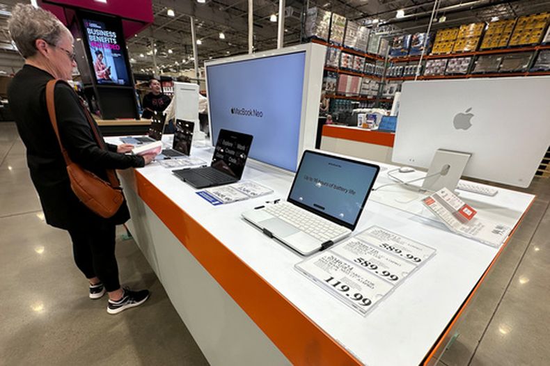 ARCHIVO - Un cliente examina computadoras portátiles Apple MacBook en exhibición en un almacén Costco el 2 de junio de 2026, en Sheridan, Colorado. (Foto AP/David Zalubowski, archivo)