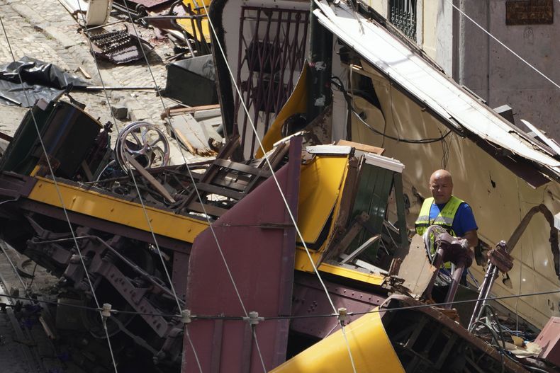 Una persona revisa los restos de un funicular turísticos que descarriló y se estrelló en Lisboa, Portugal, el 4 de septiembre de 2025. (AP Foto/Armando Franca)