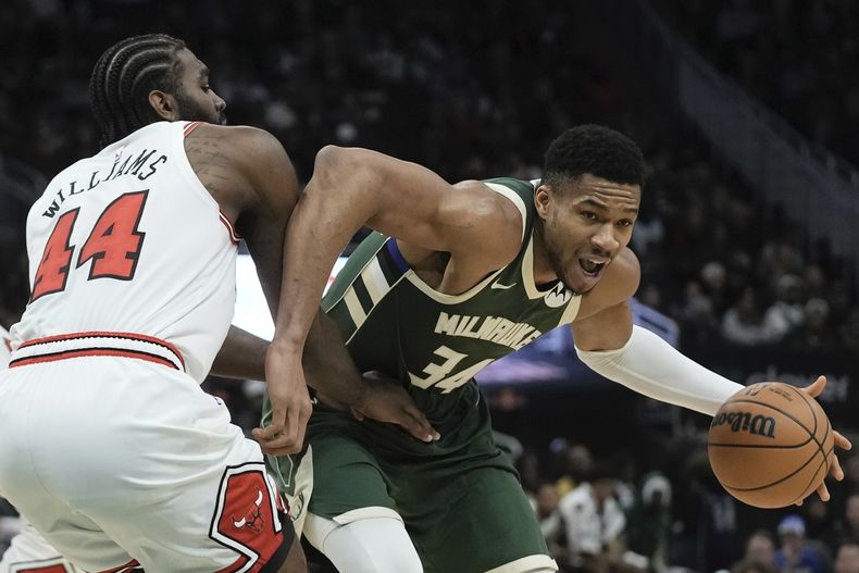 Giannis Antetokounmpo, de los Bucks de Milwaukee, intenta dejar atrás a Patrick Williams, de los Bulls de Chicago, durante la primera mitad del juego de baloncesto de la NBA, el lunes 11 de diciembre de 2023, en Milwaukee. (AP Foto/Morry Gash)