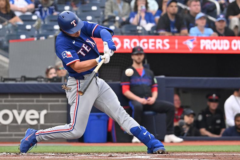 El bateador designado de los Rangers de Texas, Justin Foscue, conecta un sencillo productor de una carrera contra los Azulejos de Toronto durante la primera entrada de un partido de béisbol en Toronto, el viernes 26 de junio de 2026. (Jon Blacker/The Canadian Press vía AP)