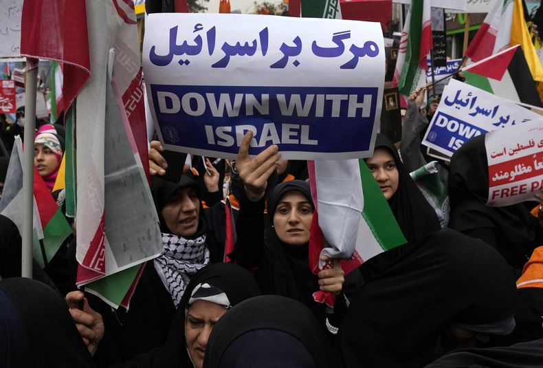 Una manifestante iraní sostiene un cartel antiisraelí durante un acto frente a la antigua embajada de Estados Unidos en Teherán, en el 44to aniversario de la toma de la embajada por activistas iraníes, sábado 4 de noviembre de 2023. Las consignas del acto, convocado por el gobierno, fueron muera Estados Unidos y muera Israel. (AP Foto/Vahid Salemi)