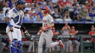 Kevin Newman, de los Rojos de Cincinnati, anota frente al cátcher venezolano Salvador Pérez, de los Reales de Kansas City, el martes 13 de junio de 2023 (AP Foto/Charlie Riedel)