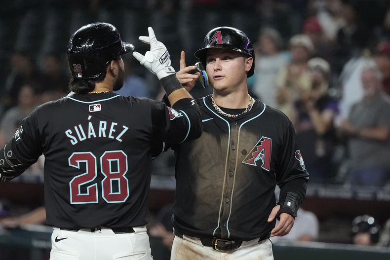 Eugenio Suárez (28), de los Diamondbacks de Arizona, celebra su grand slam en contra de los Rockies de Colorado con su compañero de equipo Joc Pederson durante la sexta entrada del juego de béisbol del miércoles 14 de agosto de 2024, en Phoenix. (AP Foto/Ross D. Franklin)