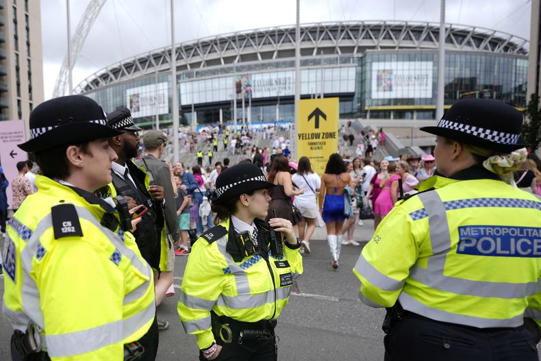 Agentes de policía observan la llegada de los fanáticos de Taylor Swift al estadio de Wembley en Londres, el jueves 15 de agosto de 2024, en el primer día de cinco conciertos de la gira Eras de Taylor Swift. (Foto AP/Alastair Grant)
