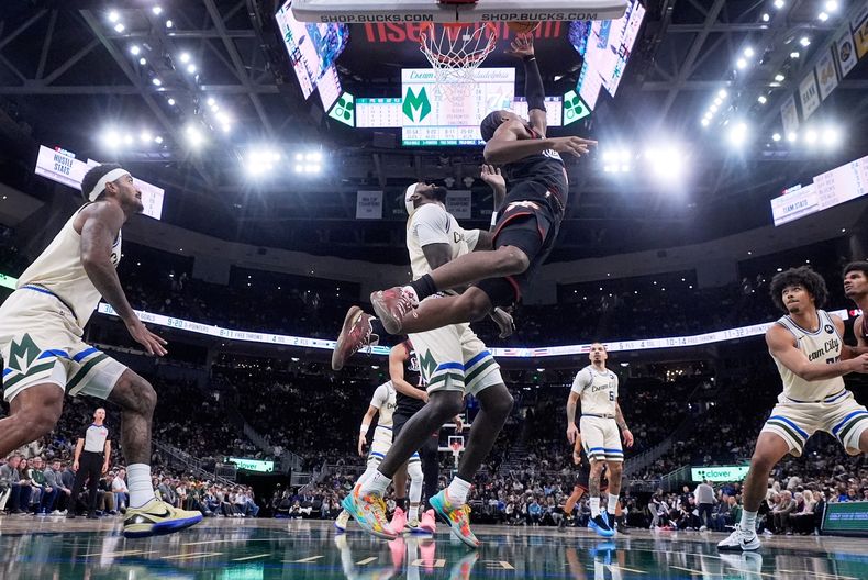 Tyrese Maxey, de los 76ers de Filadelfia, encesta frente a Bobby Portis, de los Bucks de Milwaukee, en el duelo del jueves 20 de noviembre de 2025 (AP Foto/Morry Gash)