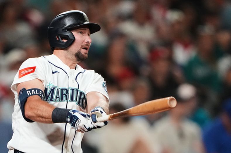 Cal Raleigh, de los Marineros de Seattle, sigue el vuelo de la pelota de un cuadrangular solitario en el juego de béisbol de Grandes Ligas contra los Filis de Filadelfia, durante la séptima entrada, el lunes 24 de agosto de 2026, en Seattle. (AP Foto/Lindsey Wasson)